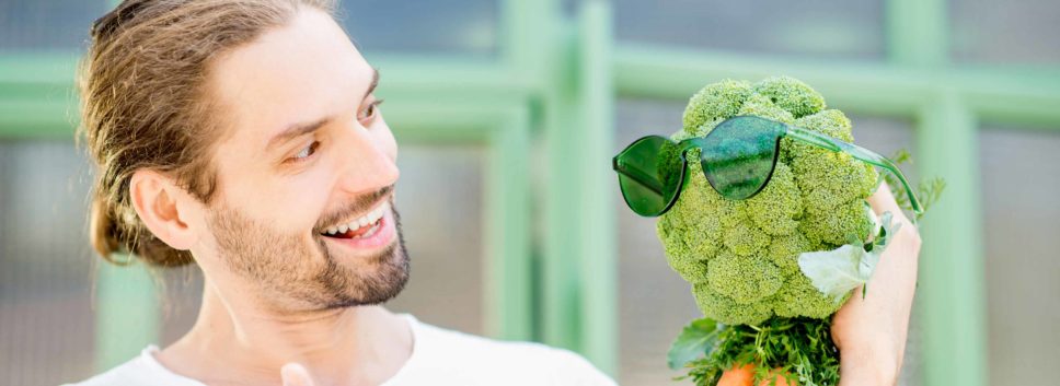 Mann spricht mit Gemüsekopf mit Sonnenbrille