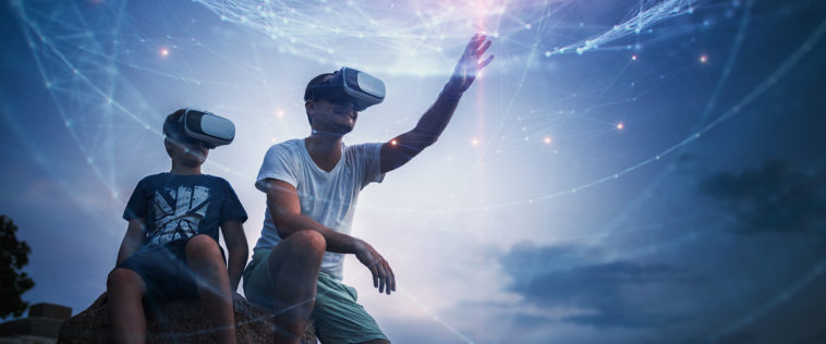 Vater mit Bub mit VR-Brille greifen nach den Sternen