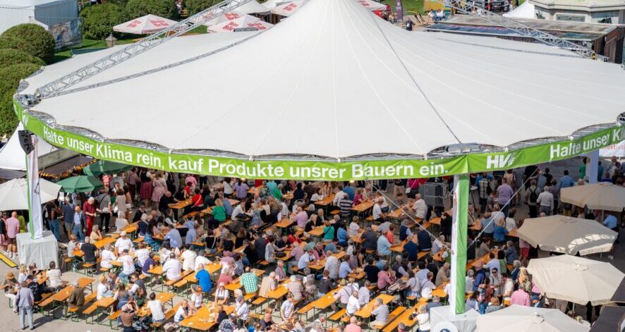 2025-09-07_EDF25_(c)ÖSF-Pöhlmann-1202 Viele Besucherinnen und Besucher sitzen an langen Tischen unter einem großen Festzelt beim ernte.dank.festival. am Wiener Heldenplatz. (c)ÖSF-Pöhlmann