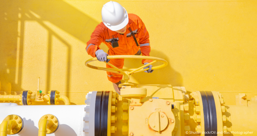 37 Arbeiter dreht an einem großen Gashahn vor gelben Hintergrund (c) shutterstock/Oil and Gas Photographer