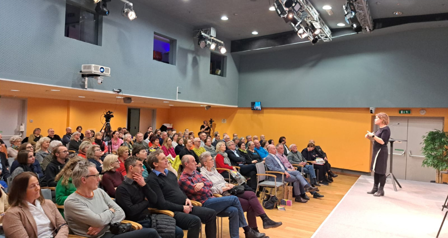 Ökosoziales Forum Oberösterreich Buchlesung von Ingrid Brodnig füllte den Vortragssaal2 Publikum bei einer Buchveranstaltung: Ingrid Brodnig steht auf der Bühne und spricht vor einem voll besetzten Vortragssaal mit zahlreichen Zuhörerinnen und Zuhörern.